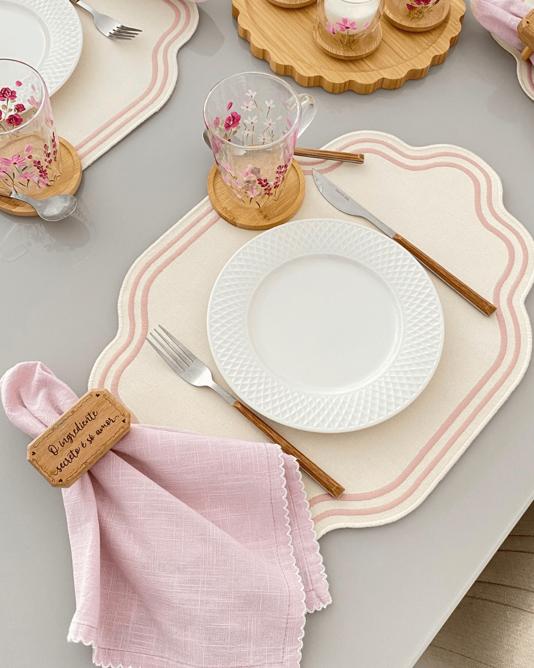 Mesa posta com pratos, talheres e guardanapo, ensinada no guia